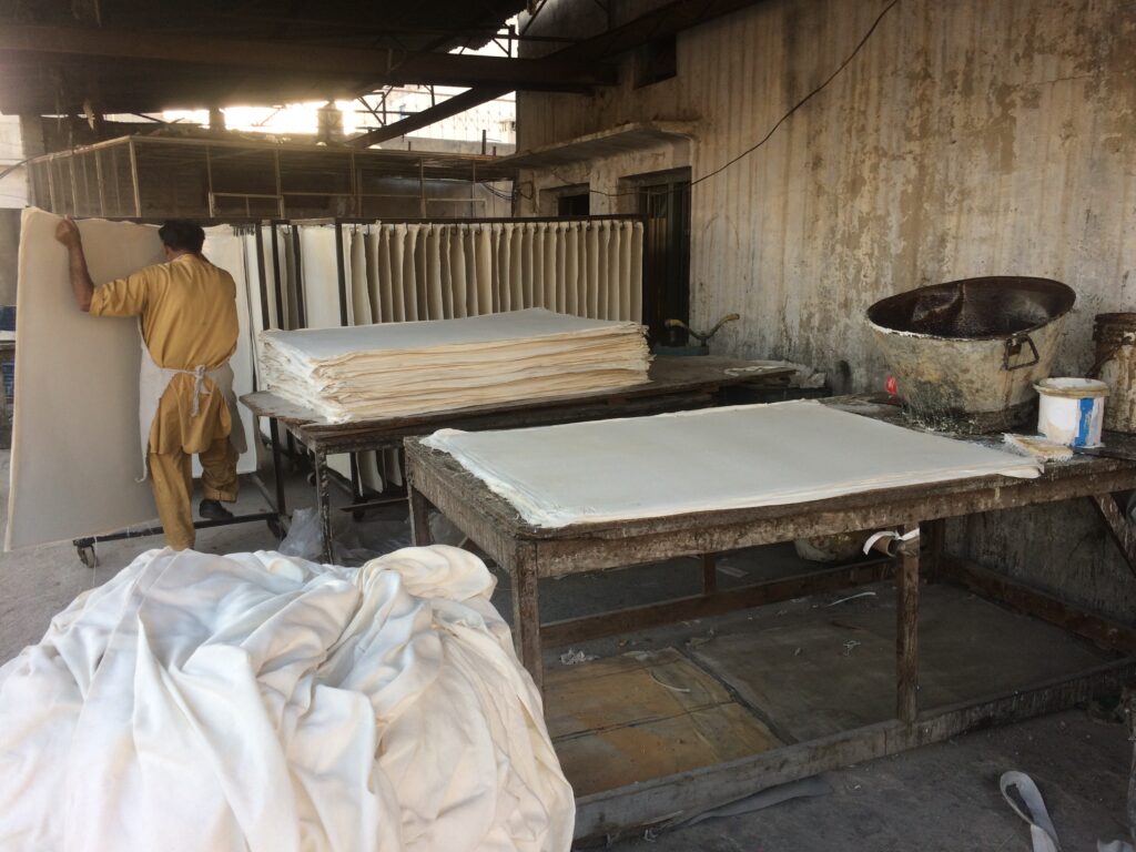 Hand stitching soccer ball panels in factory by skilled workers in Sialkot